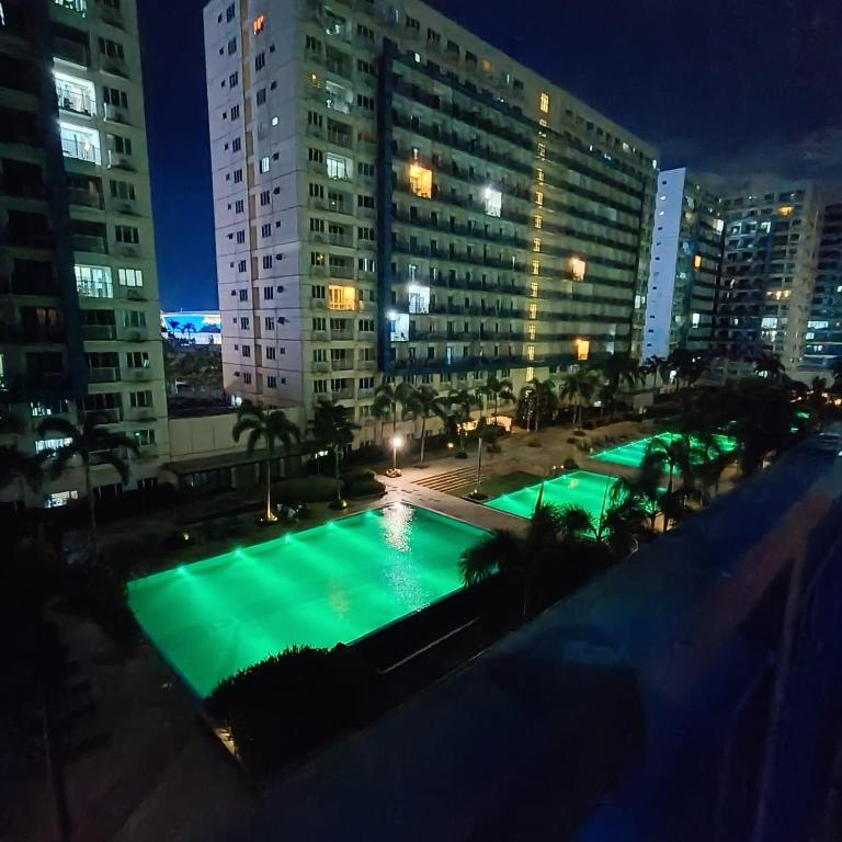 - une vue sur la piscine de la ville la nuit dans l'établissement Phert's apartment, à Manille