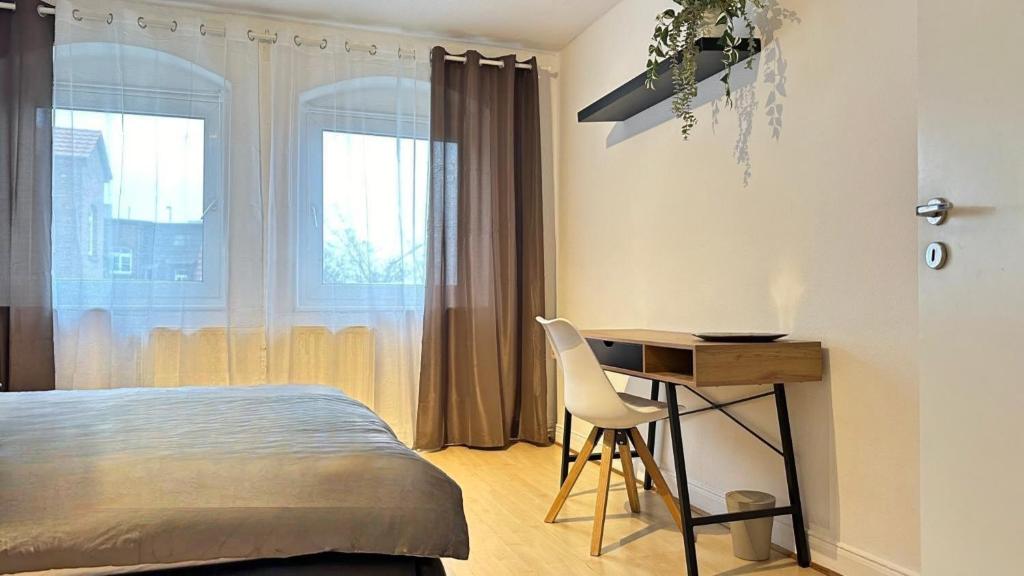 1 dormitorio con cama, escritorio y silla en Stadion Apartment für 4 Personen en Kassel