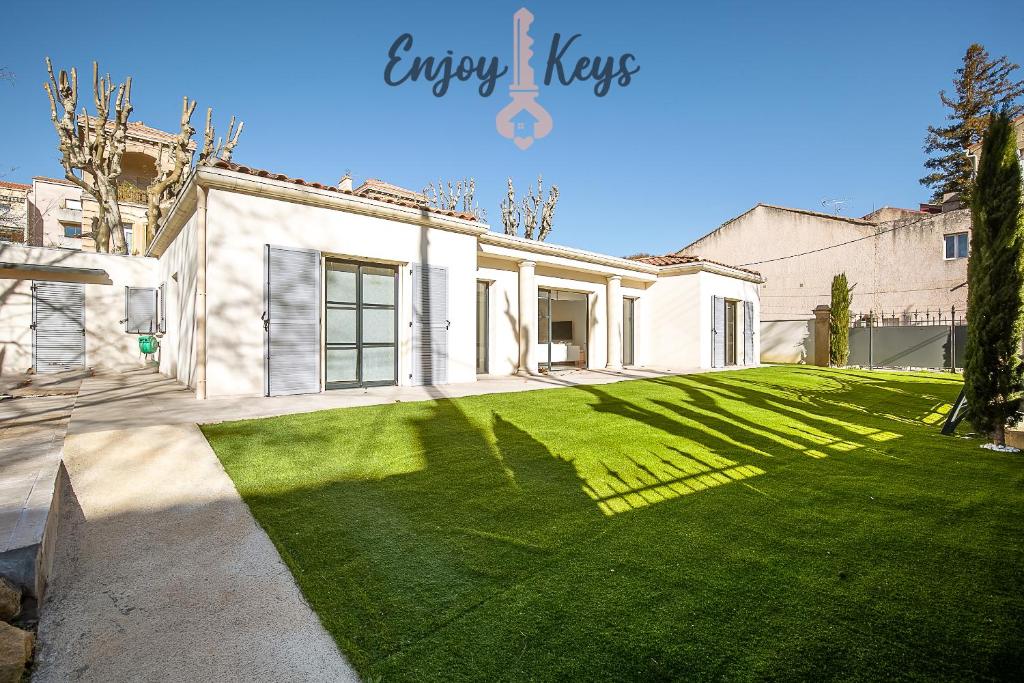 une grande maison blanche avec une grande pelouse dans l'établissement Maison au cœur de la ville, à Salon-de-Provence