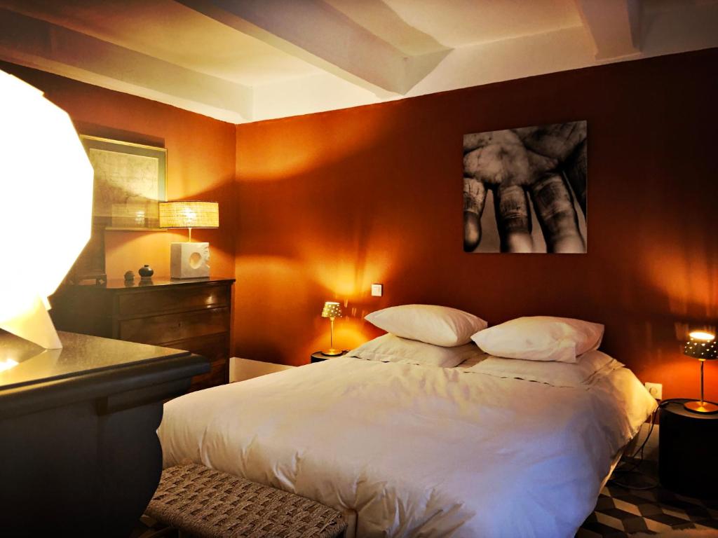 a bedroom with a large bed with orange walls at B&B Vigne Vierge in Aigne