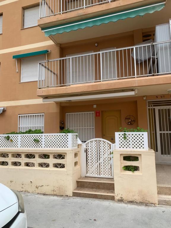una casa con recinzioni bianche e un balcone di Apartamento en la playa a Tavernes de Valldigna