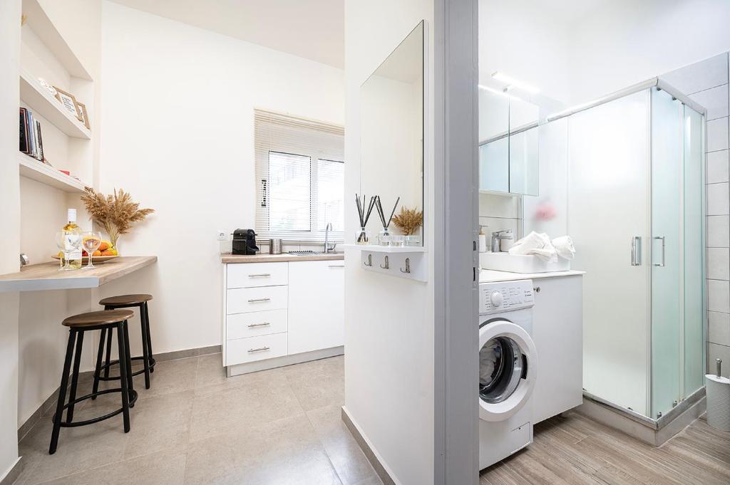 a white laundry room with a washer and dryer at Coastal Elegance Suite 1-Min to the Beach in Ampavris