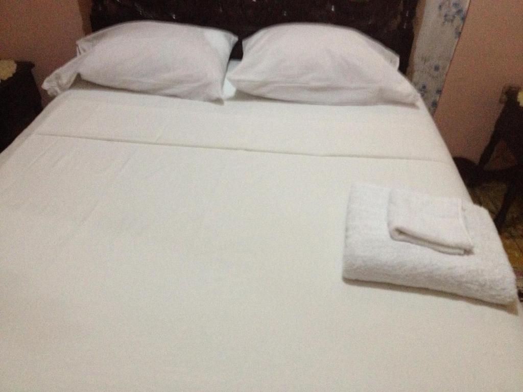 - un lit blanc avec une serviette blanche dans l'établissement Kingston Airport bed and breakfast, à Kingston