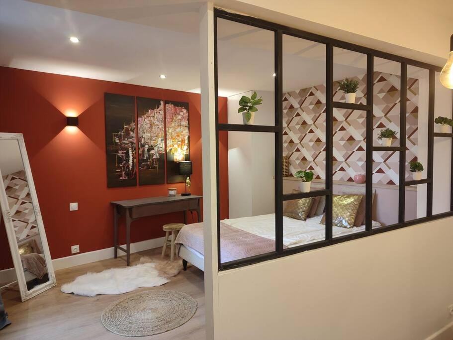 ein Schlafzimmer mit einem Bett und einem Schreibtisch in einem Zimmer in der Unterkunft Appartement Rose in Nogent-sur-Seine