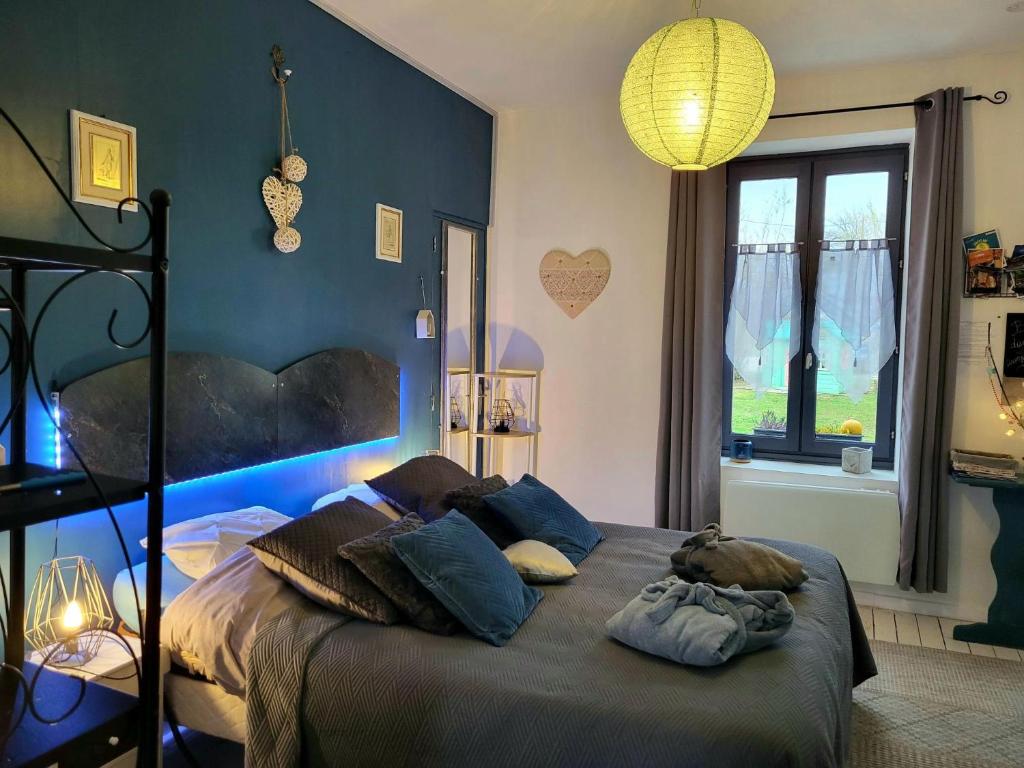 ein Schlafzimmer mit einem großen Bett mit blauen Wänden in der Unterkunft Chez Christy Chemin des Dinots in Saint-Bonnet-de-Four