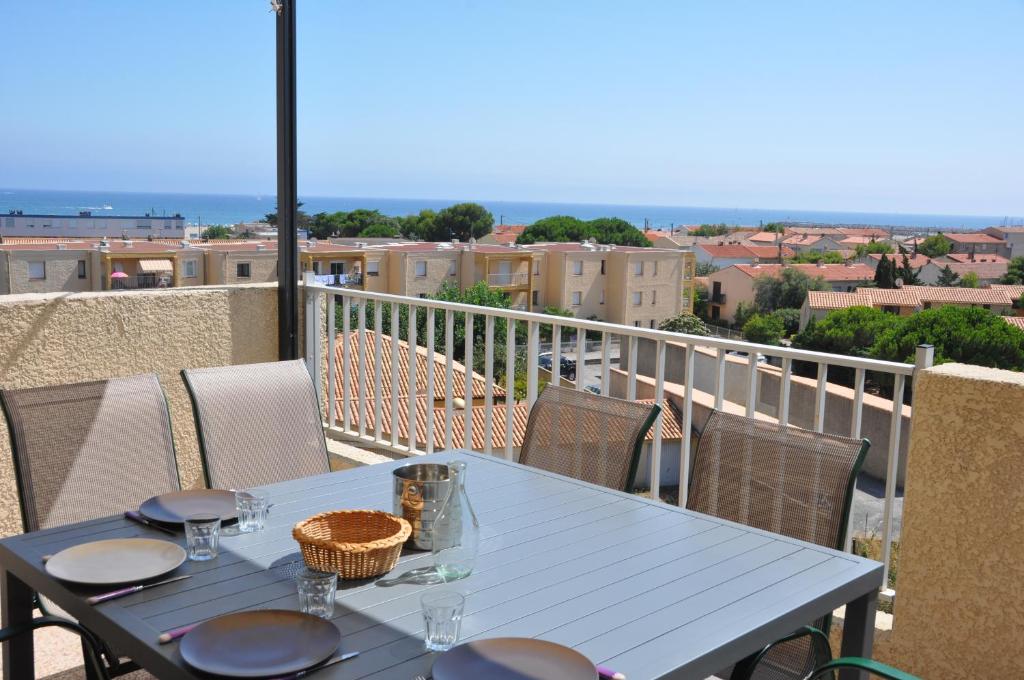 a blue table on a balcony with a view at Arc en ciel, vue mer et piscine dans résidence in Saint Pierre La Mer