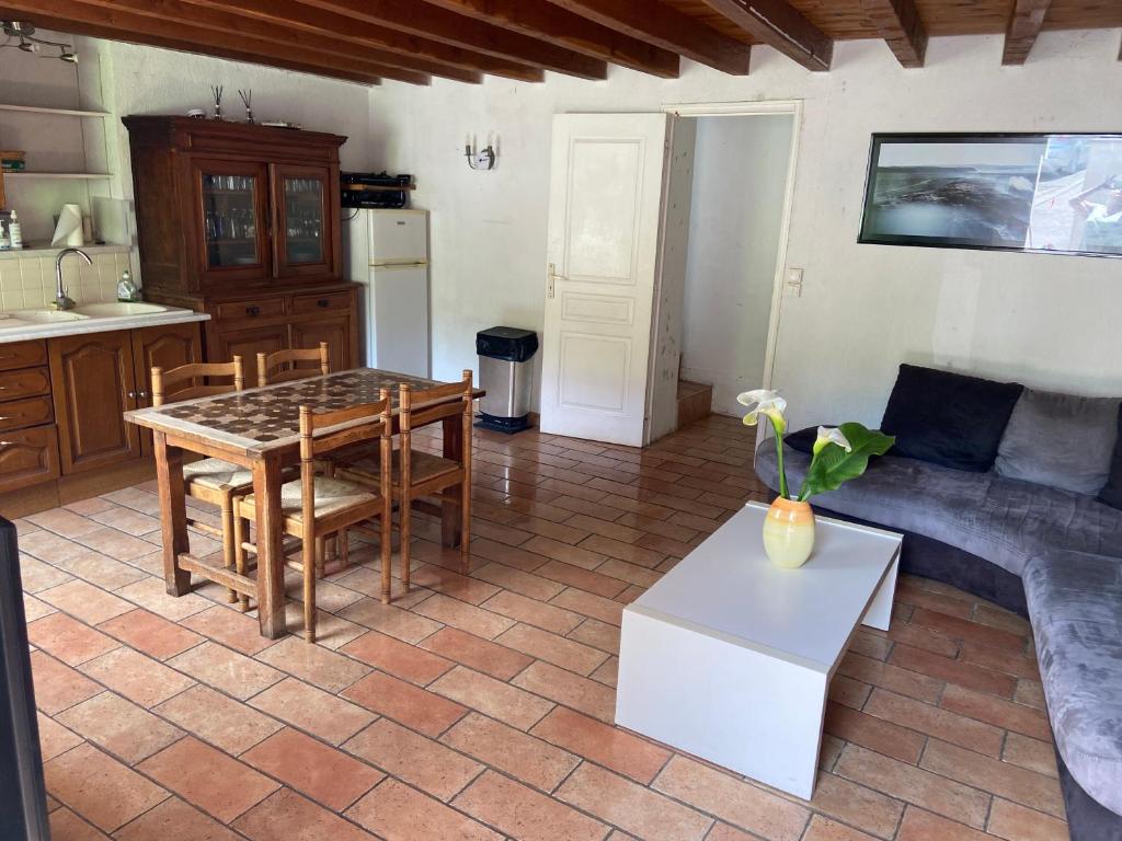 una cucina e un soggiorno con tavolo e sedie di Maison au calme a l'orée du bois. Accès A13-A14 a Orgeval