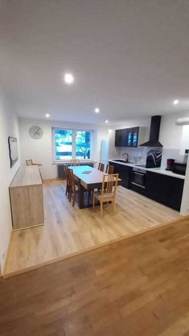 une cuisine et une salle à manger avec une table dans une pièce dans l'établissement Appartement lumineux avec balcon, à Gérardmer