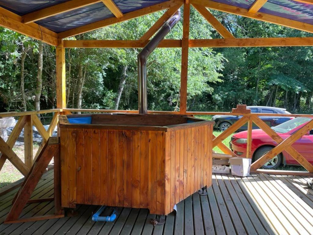 - un kiosque en bois avec une table en bois sur une terrasse dans l'établissement Cabaña Melipeuco, à Melipeuco
