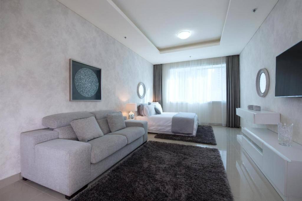 Marina Studio - KV Hotels في دبي: غرفة معيشة مع أريكة وسرير