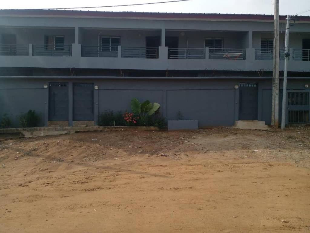 a building with a dirt yard in front of it at Lovely 1-Bed duplex house in Abidjan