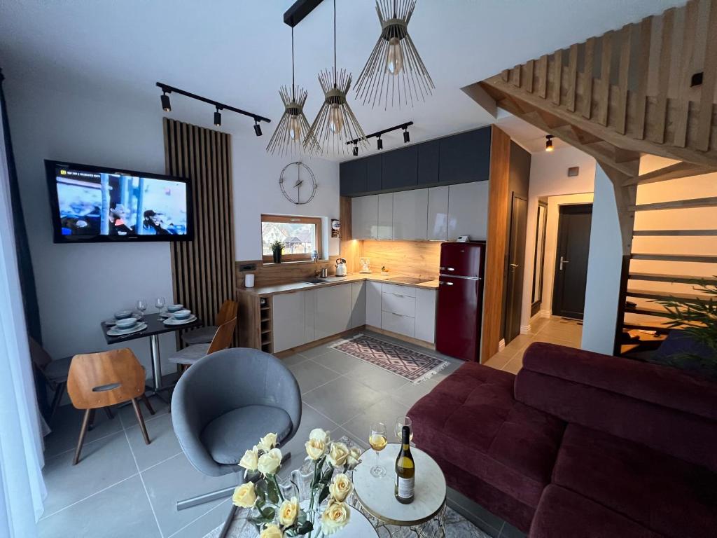 ein Wohnzimmer und eine Küche mit einem Sofa und einem Tisch in der Unterkunft Villa Monte Apartament z ogrodem in Kudowa-Zdrój
