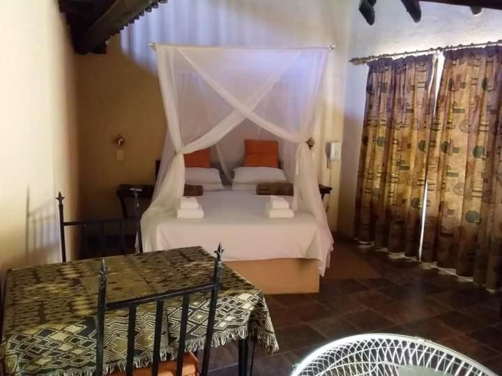 a bedroom with a bed with a canopy at iGowati Country Hotel in Khorixas