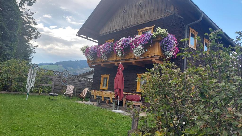 ein Haus mit einem Balkon mit Blumen darauf in der Unterkunft Boahäusl in Flachau