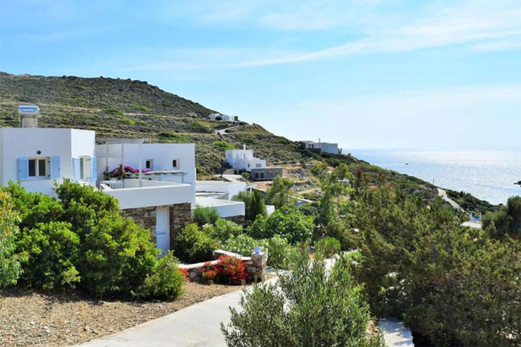 a house on a hill with the ocean in the background at Luxurious Villa on the famous glp cat sanctuary in Kinion