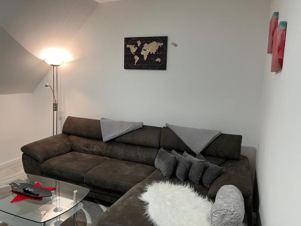 sala de estar con sofá marrón y mesa en Ferienwohnung, Monteurwohnung, Unterkunft in Warstein NRW, Deutschland en Warstein