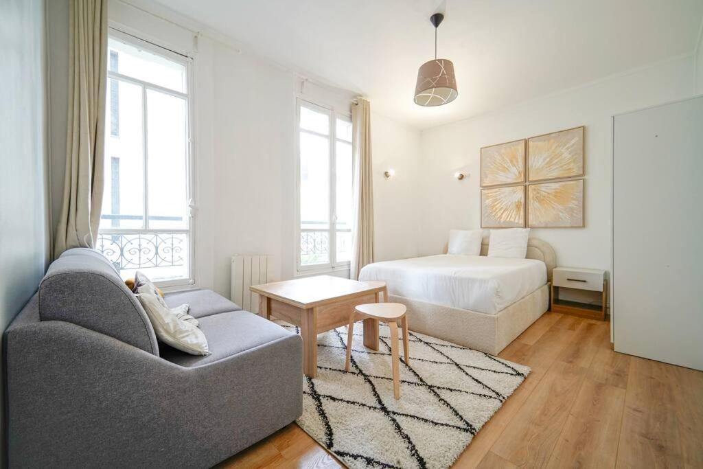 un salon avec un canapé et un lit dans l'établissement Studio Buttes-Chaumont - Hautpoul - IV, à Paris