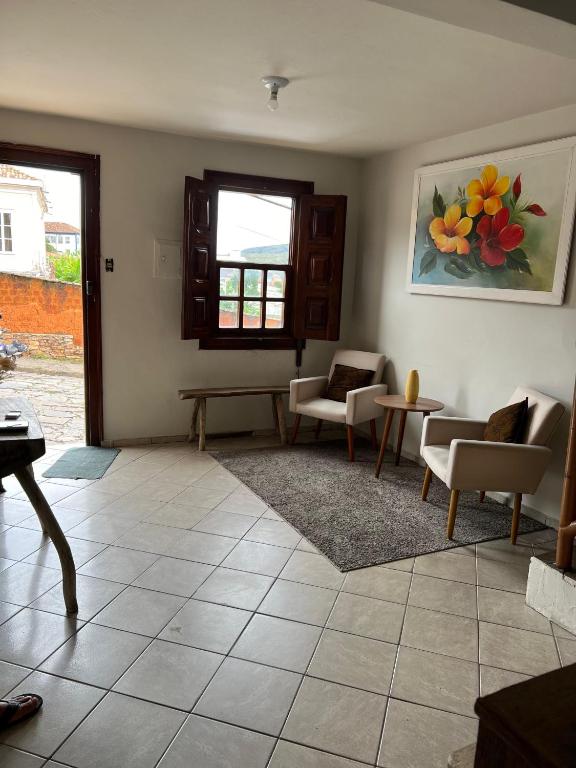 a living room with chairs and a table and a window at Hostel Diamante in Diamantina