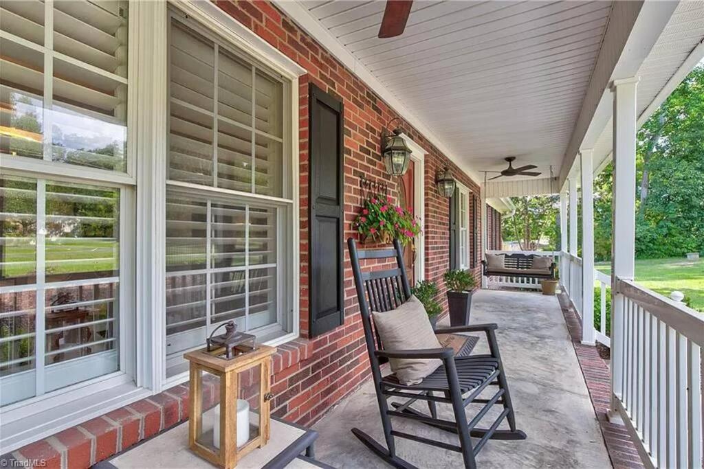 einen Schaukelstuhl auf der Veranda eines Hauses in der Unterkunft Fantastic Cottage with big backyard near the city in Greensboro