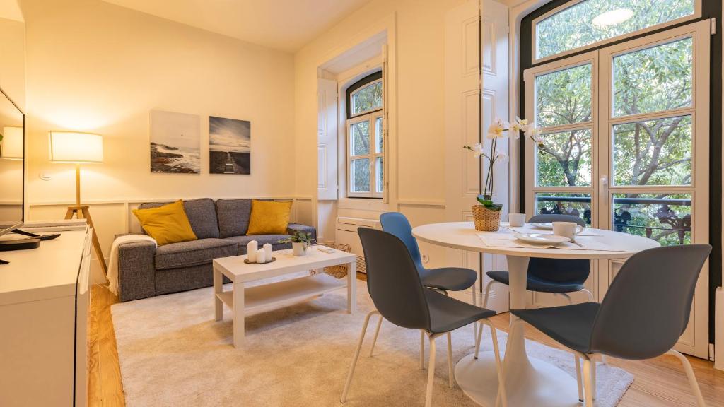 uma sala de estar com uma mesa e cadeiras e um sofá em 2BDR Alcântara Nest by LovelyStay em Lisboa