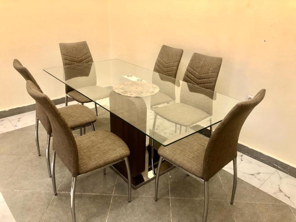 mesa de comedor de cristal con sillas y mesa y sillas de cristal en RESIDENCE E.P, en Emana