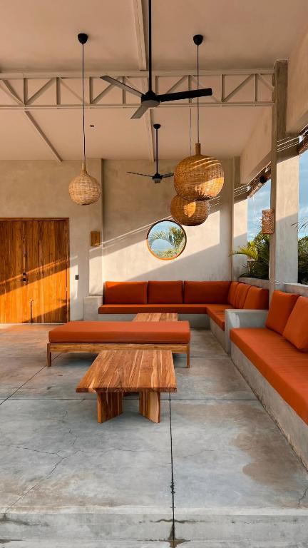 a living room with orange couches and a table at Tukasa - Surfhouse Popoyo in Popoyo