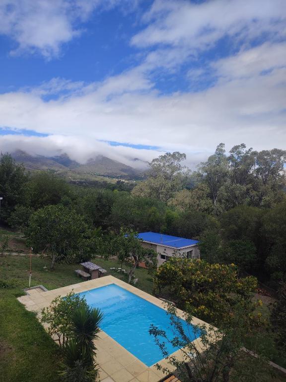a swimming pool in front of a house with a mountain at Cabañas Olluhuasi in Valle Hermoso