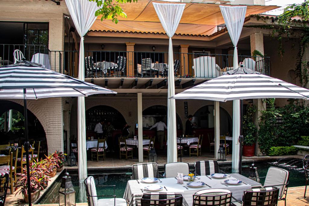 a patio with tables and umbrellas in a restaurant at Il Piccolo Peccato in Cuernavaca