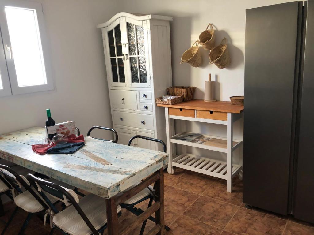 uma cozinha com uma mesa com cadeiras e um armário em Casita Volcan Lanzarote em Ye