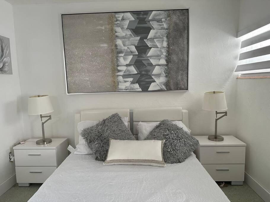 Un dormitorio con una cama con almohadas y una pintura en Villa Clara SUITE - Little Havana, en Miami