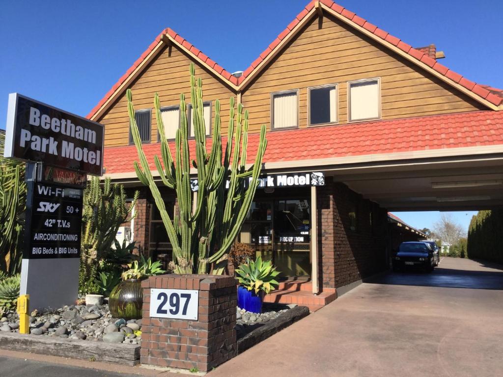 a house with a cactus in front of a garage at Beetham Park Motel in Hamilton