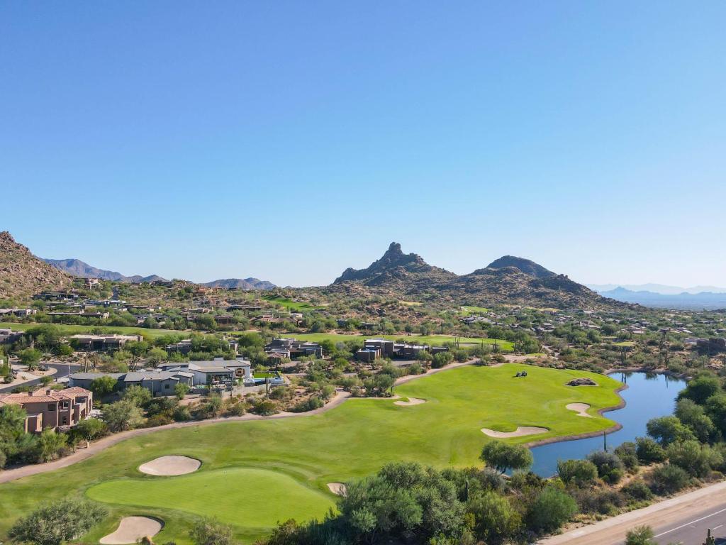 an aerial view of a golf course with a lake and mountains at Residence 1: The Villas At Troon North in Scottsdale