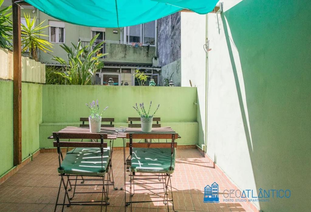 einen Tisch und Stühle mit Sonnenschirm auf einer Terrasse in der Unterkunft Porto Sé Classic Terrace Apartment in Porto