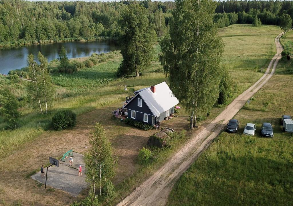 una pequeña casa en un campo junto a un río en Meza Skuki en Vabole