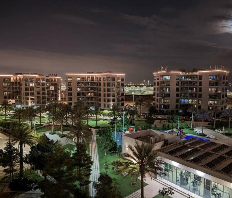 widok na miasto w nocy z wysokimi budynkami w obiekcie Modern 1BR in Dubai South Mag5 with all utilities w Dubaju