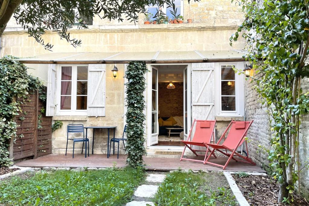 d'une terrasse avec des chaises rouges et une table. dans l'établissement Le Jardin - Pl St Sauveur - Hypercentre, à Caen