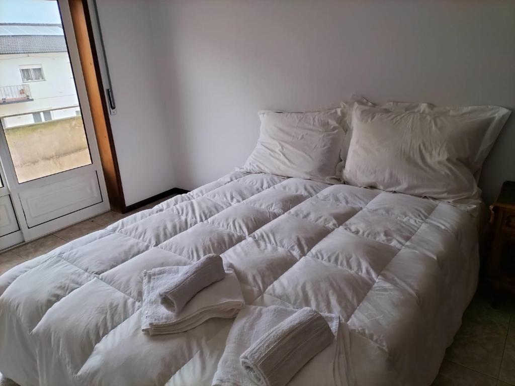 a white bed in a room with a window at Casa da Praia in Praia de Mira