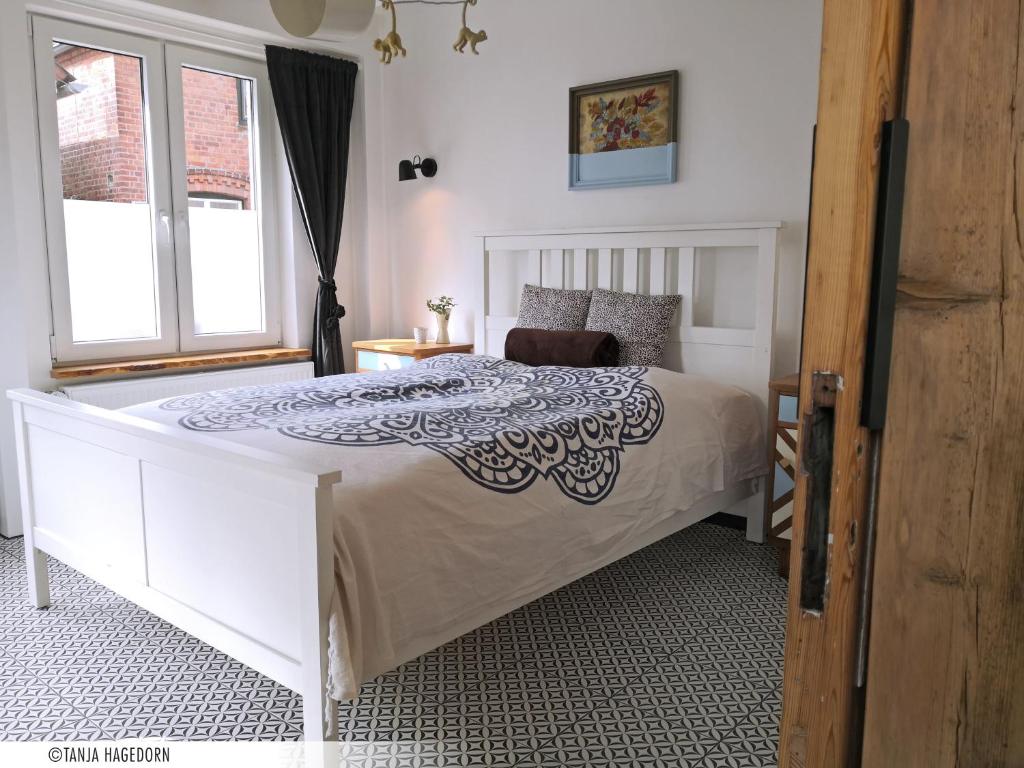 a bedroom with a white bed with a black and white comforter at Ferienwohnung im alten Milchladen in Oberndorf