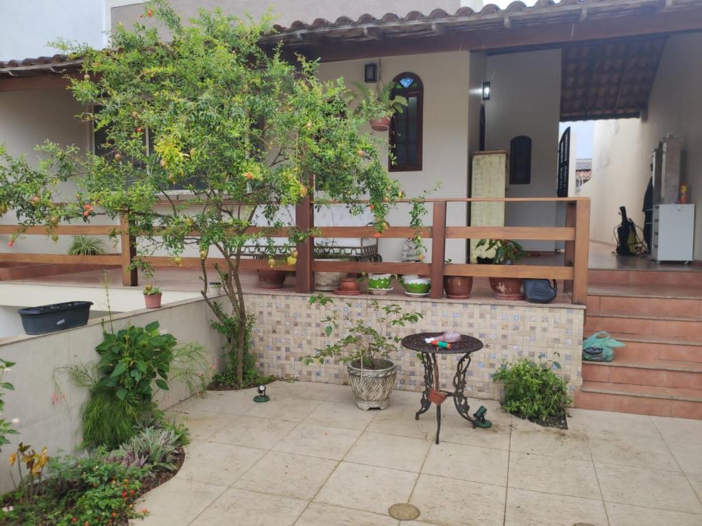 a patio with a table and potted trees at Casa de praia em Cabo Frio até 12 hospedes in Cabo Frio
