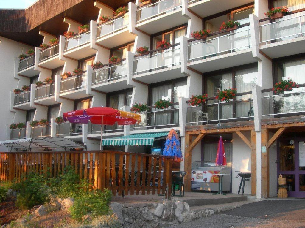 an apartment building with an umbrella in front of it at Résidence le Galaxie in Villard-de-Lans