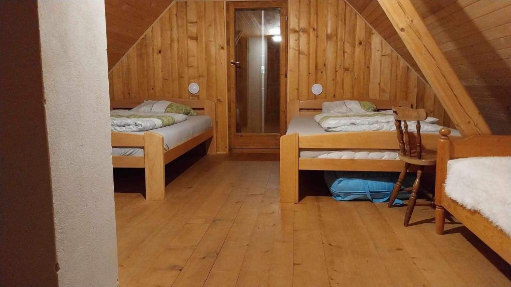a room with two beds in a wooden cabin at Počitniška hiša Jeklar in Bohinj