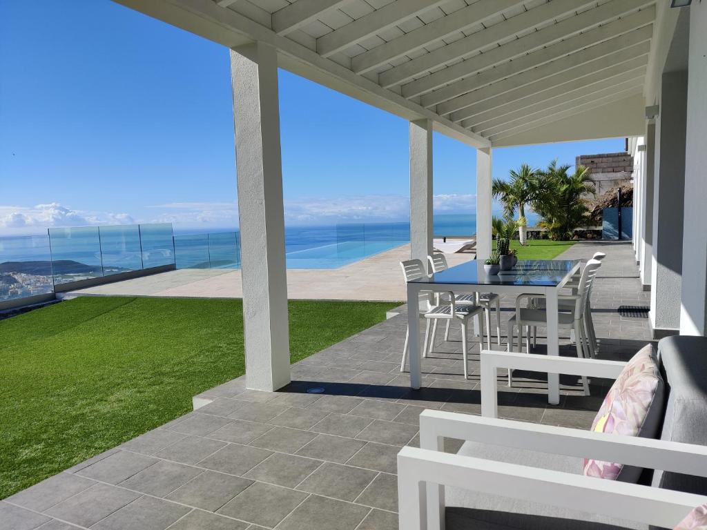 a porch with a table and chairs and the ocean at Villa Taburiente in El Paso