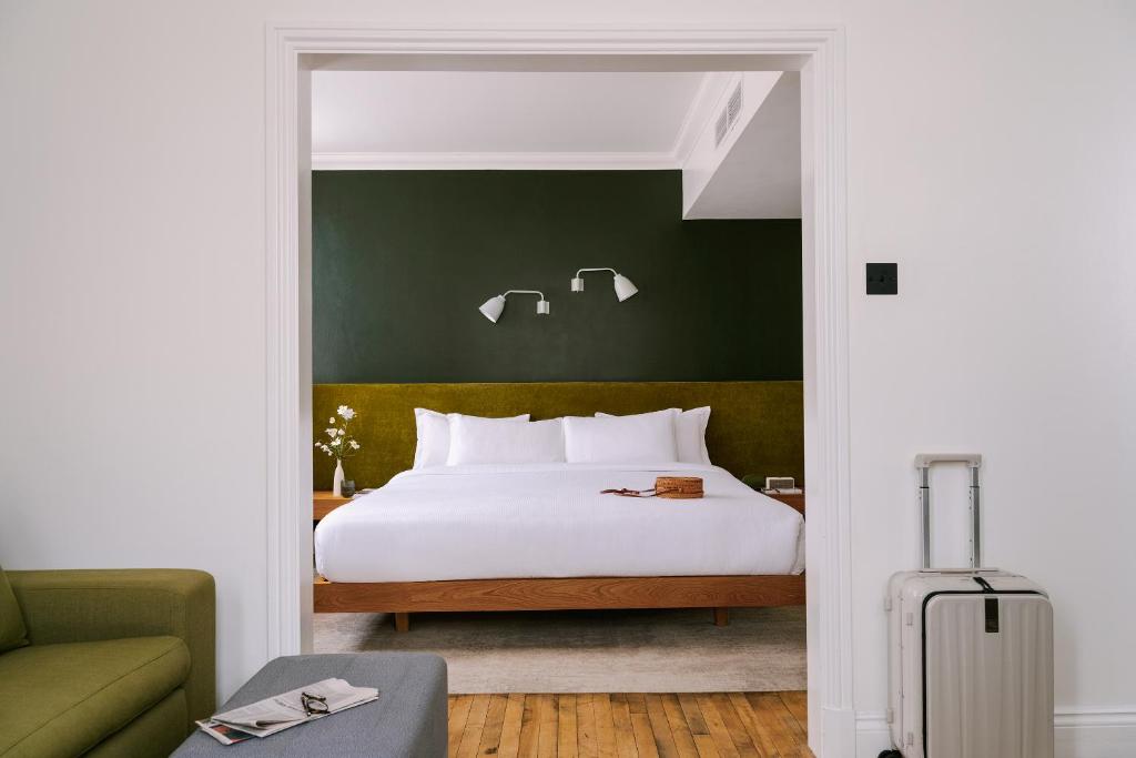 a bedroom with a white bed and a green wall at Sonder Chelsea Green in London
