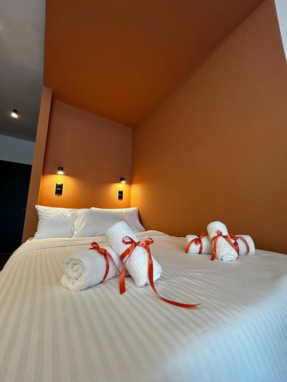Una cama con toallas blancas con arcos rojos. en Orange Luxury apartment in agrinio en Agrinio