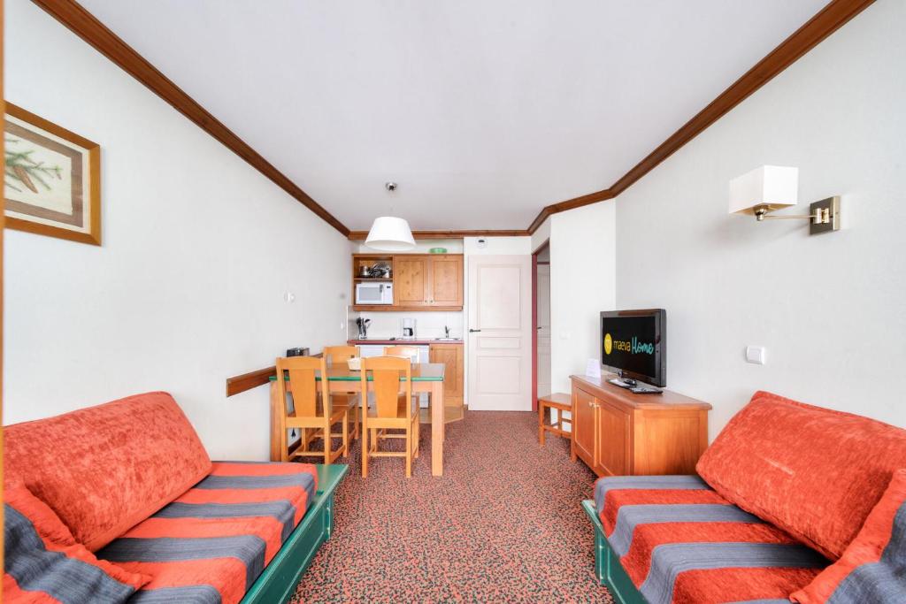 un salon avec deux canapés et une cuisine dans l'établissement Résidence La Marelle et Le Rami - maeva Home - Appartement 2 pièces 5 personnes - Sélection MAE-8644, à La Plagne Tarentaise