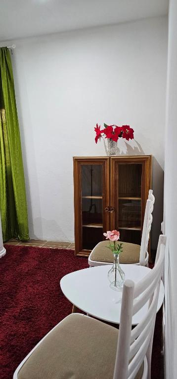 a table and chairs with a vase of flowers on it at AG Euro Apartments in Gabčíkovo