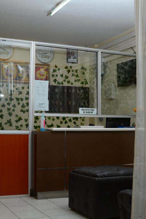 une salle d'attente avec une fenêtre à feuilles vertes dans l'établissement QUINTEN HOTEL KISUMU, à Kisumu