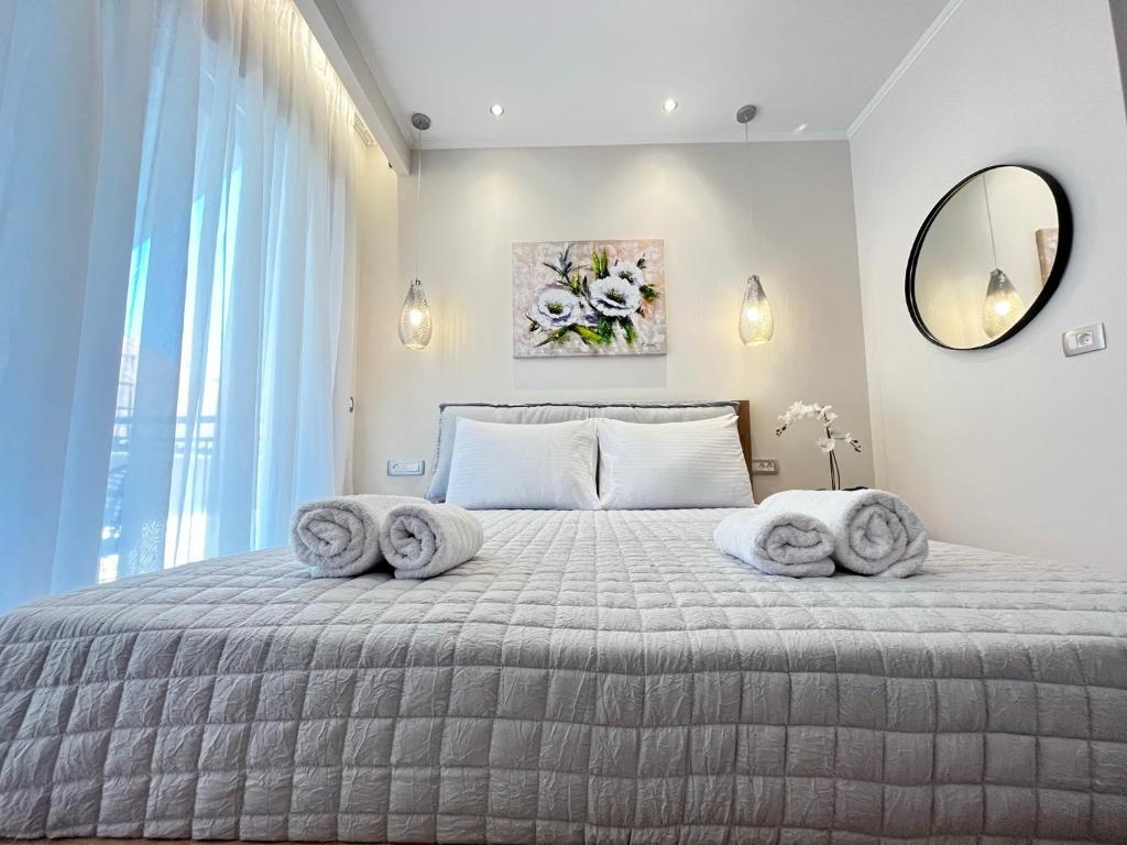 a bedroom with a large bed with towels on it at Maison deluxe studios and apartment in Parga