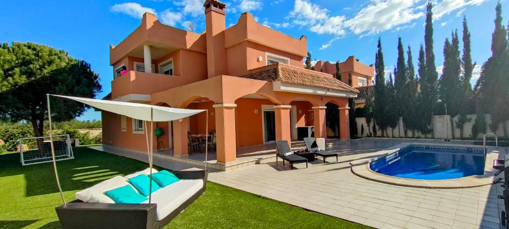 a house with a swimming pool in the yard at Villa Veneziola La Manga in Murcia