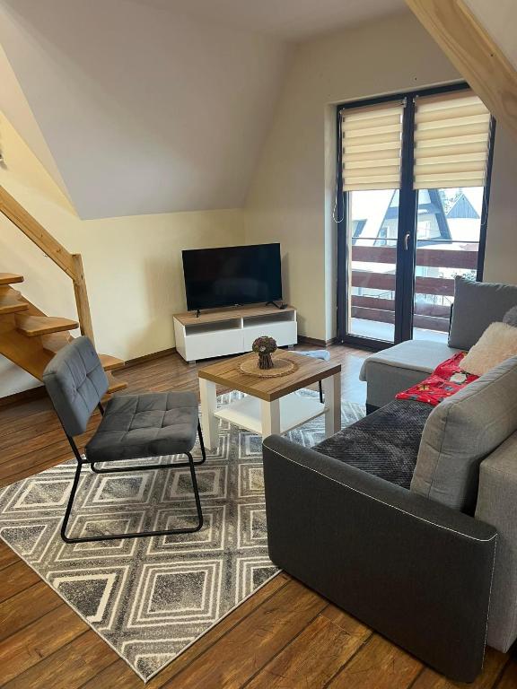 ein Wohnzimmer mit einem Sofa und einem Tisch in der Unterkunft Apartament u Mrugały in Biały Dunajec